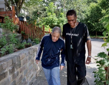 a man helps an older man walk