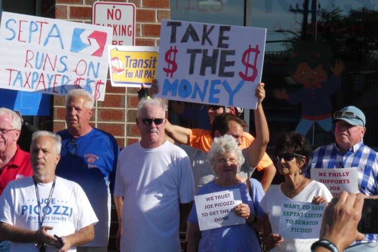 Supporters of Picozzi hold signs outside his office