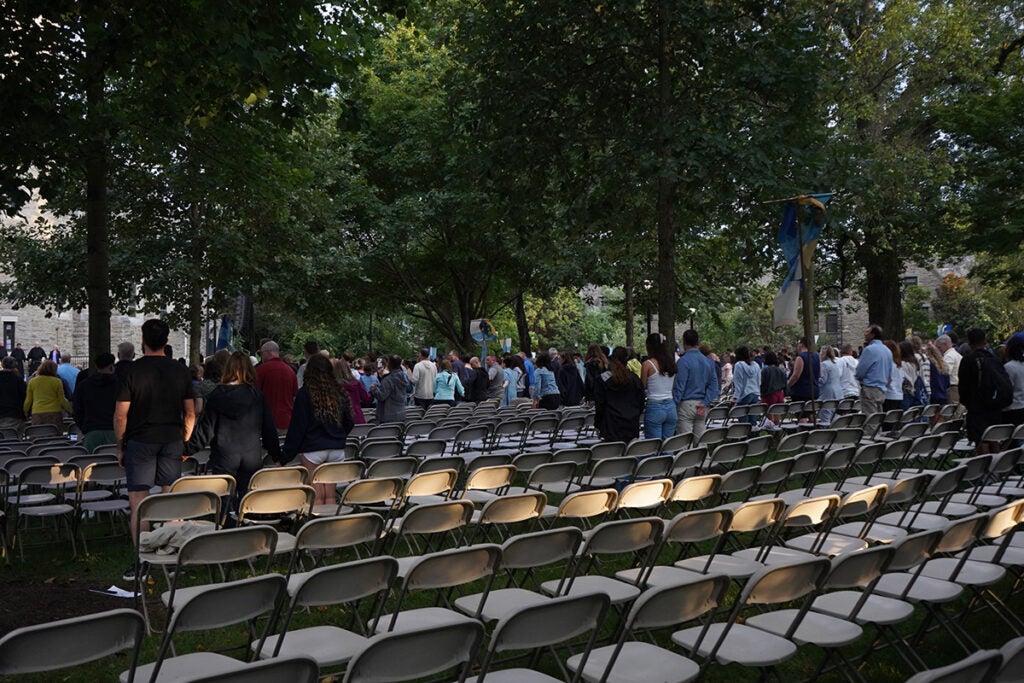 Villanova University students stand among rows of chairs on campus