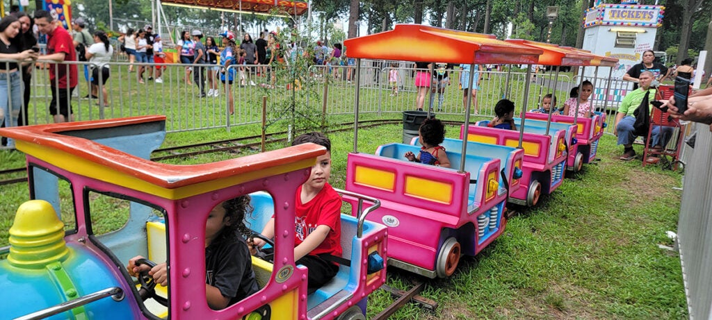 Children sit aboard a small toy train at the Vineland Puerto Rican Festival