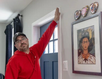 A man checks for air leakages at a home's door