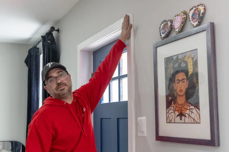 04-22-2024-k-paynter-reduced-size-home-energy-audit-file-new A man checks for air leakages at a home's door