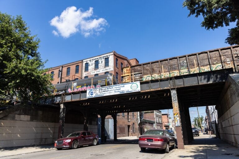A street with a train bridge running over it
