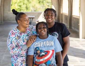 A mother posing for a photo with her two children