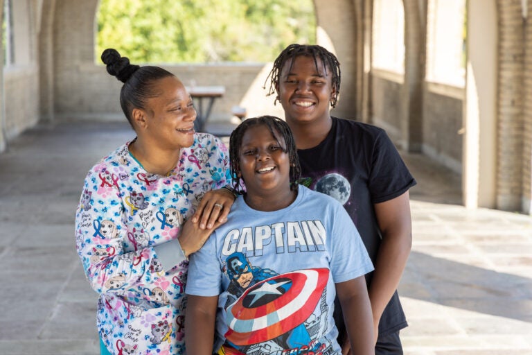 A mother posing for a photo with her two children