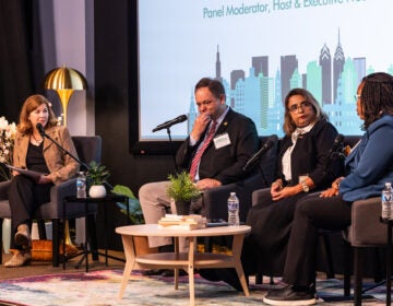 Four people sitting on stage for the panel discussion