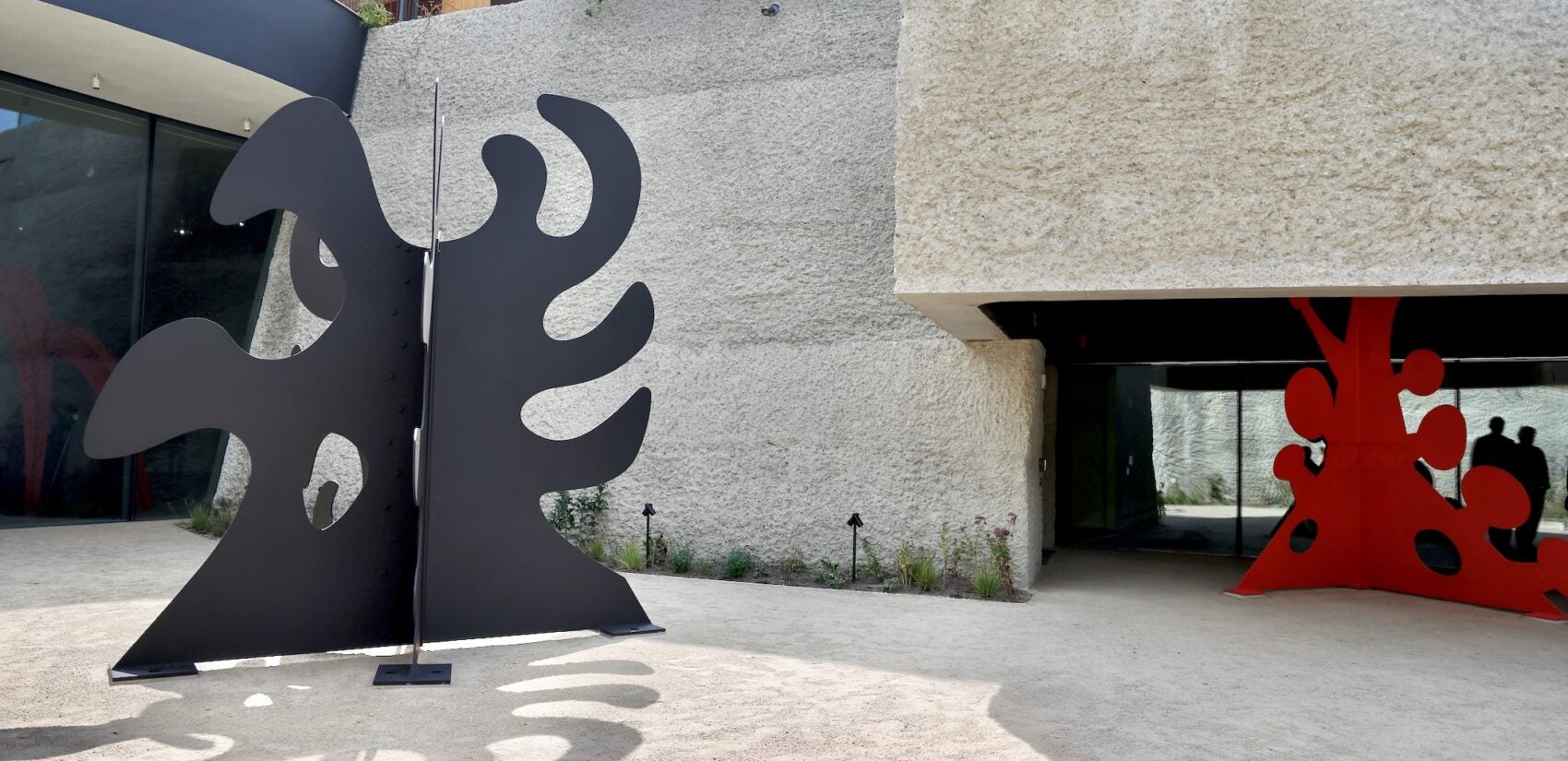 Two sculptures occupy an indoor-outdoor space at Calder Gardens