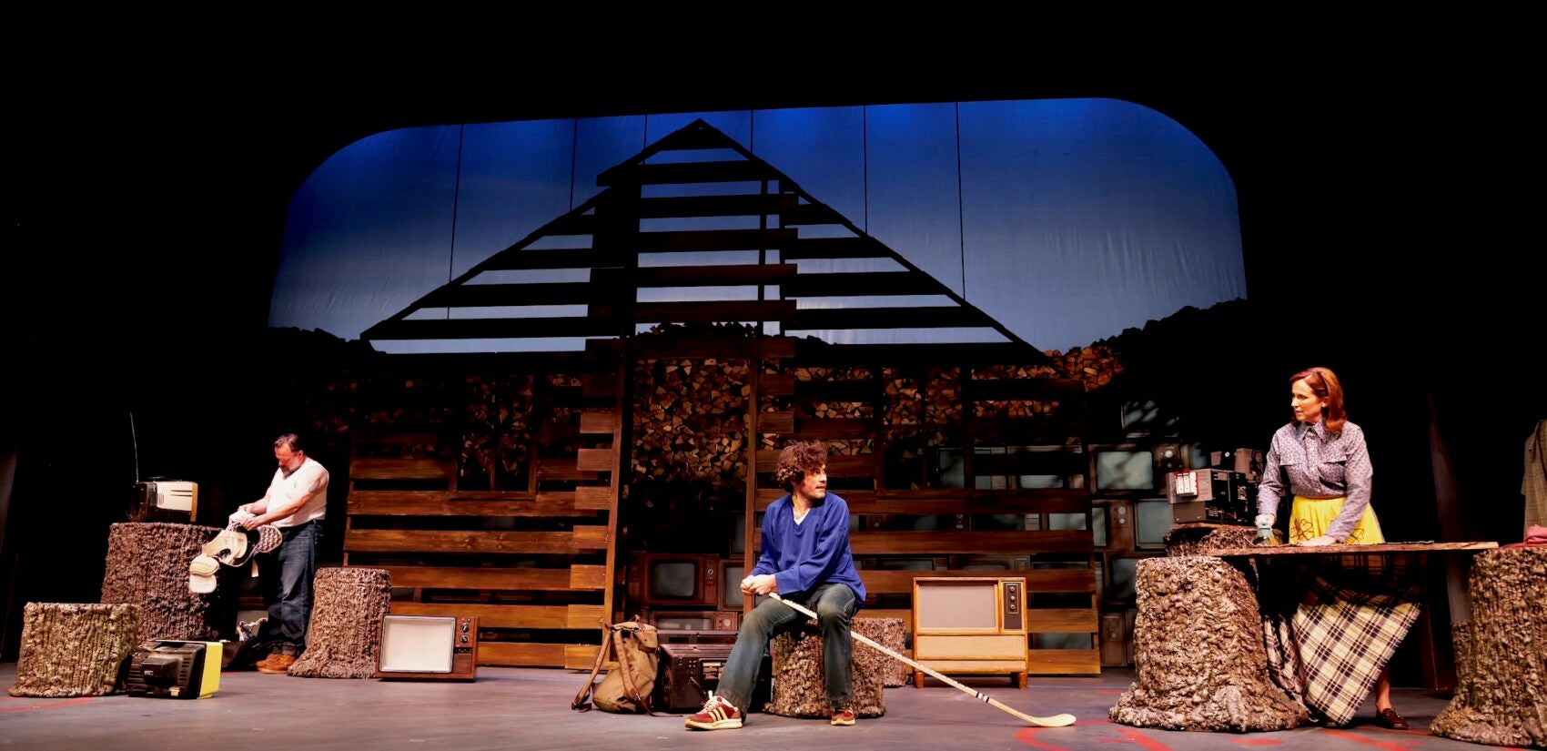 Three people on stage performing a scene from the play
