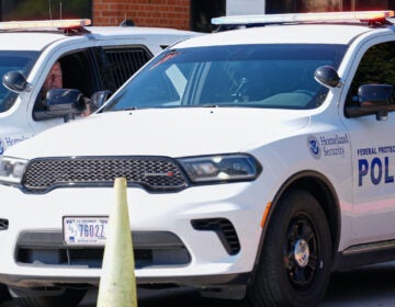 Homeland security personnel sit in their vehicles