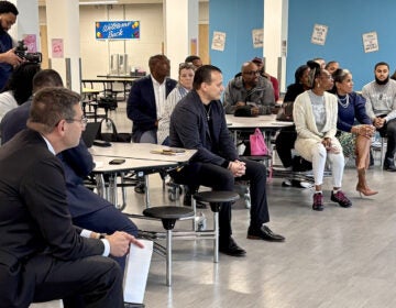 People sit in chairs at a Delaware community listening session about gun violence