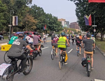 A group of cyclists ride their bikes through Philadelphia