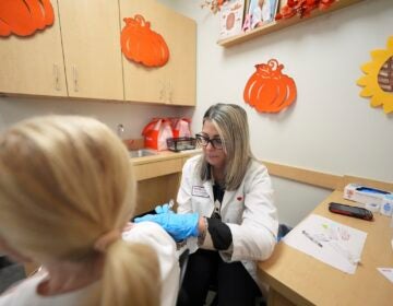 Pharmacy manager Aylen Amestoy administers a patient with a COVID-19 vaccine