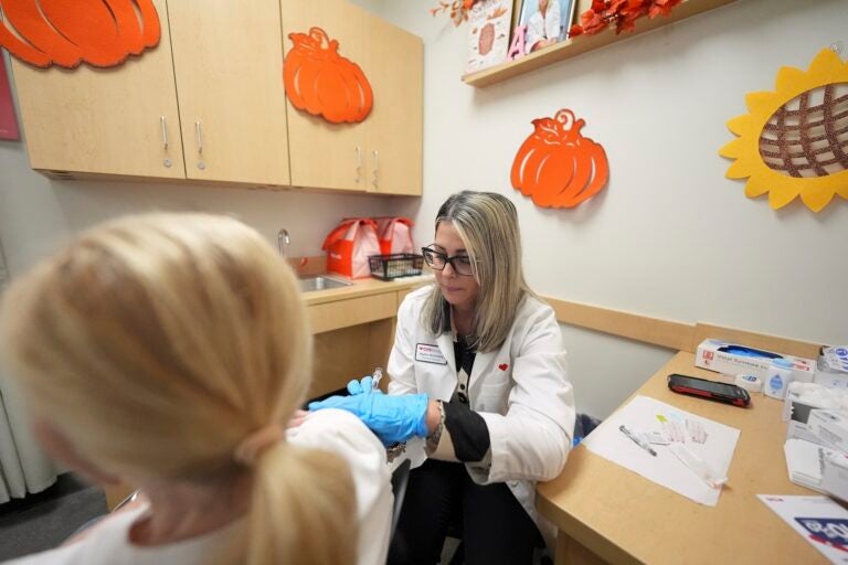 Florida Vaccines Pharmacy manager Aylen Amestoy administers a patient with a COVID-19 vaccine
