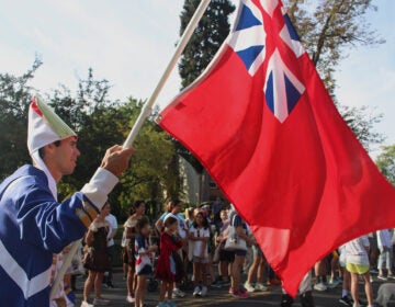 A man holds a flag for the British Army as part of a Revolutionary War re-enactment in Moorestown, New Jersey