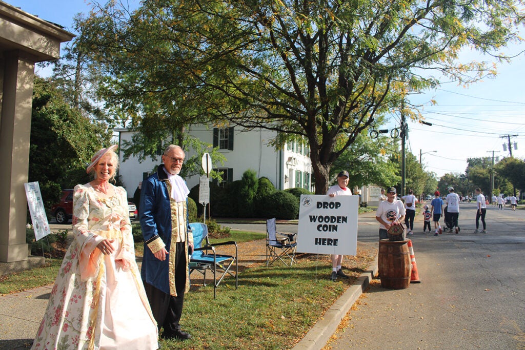 People stand dressed in 18th century clothing in Moorestown