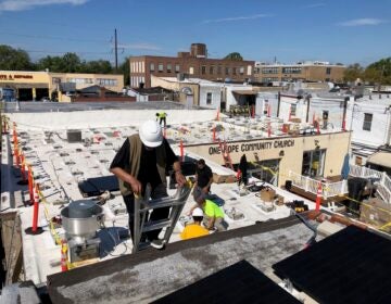 Solar installers set up an array on the roof of One Hope Community Church in Hunting Park.