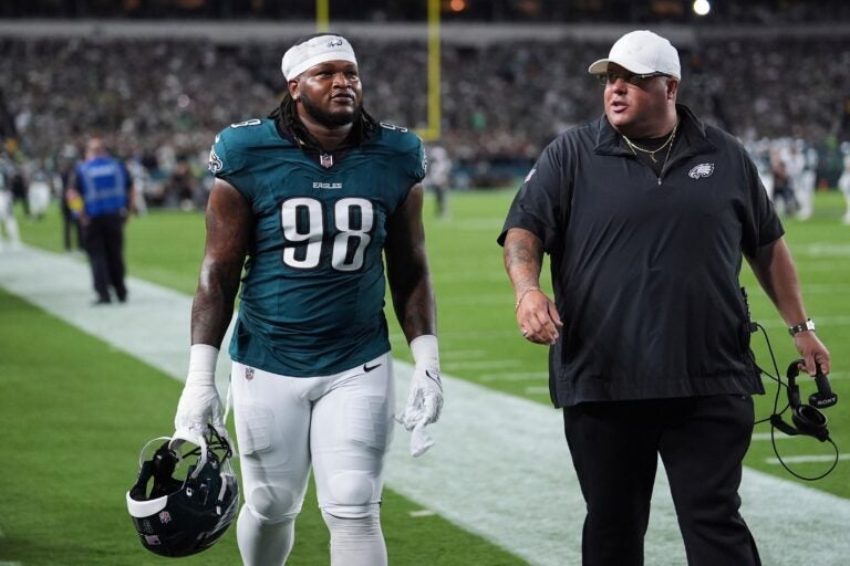 Jalen Carter walks alongside Big Dom on the Eagles sideline
