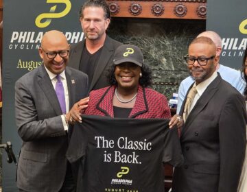 Mayor Parker holding up a t shirt at the press conference with other officials