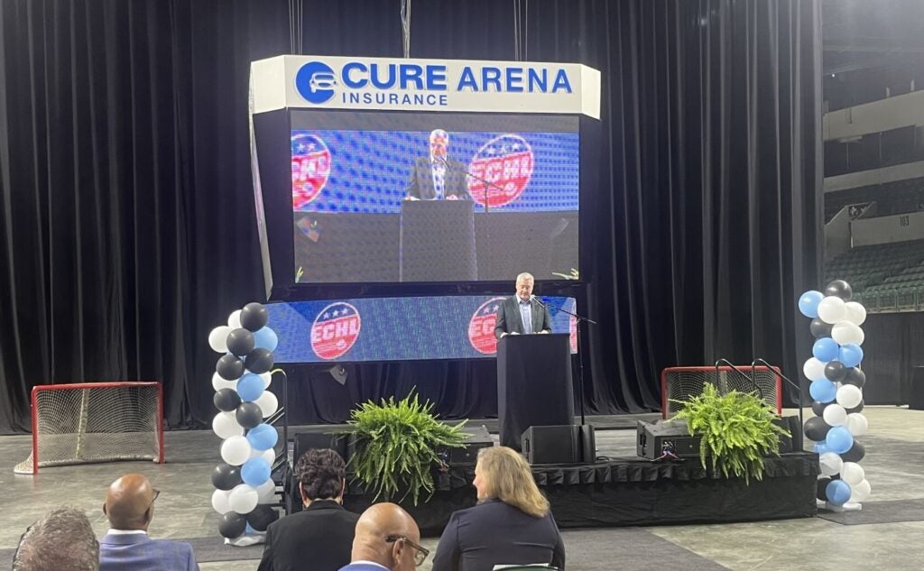 Dan Benson speaking at a podium on stage