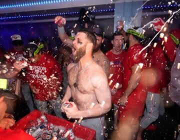 Philadelphia Phillies' Bryce Harper, center, celebrates after the Phillies clinched the NL East following their defeat of the Los Angeles Dodgers Monday, Sept. 15, 2025, in Los Angeles.