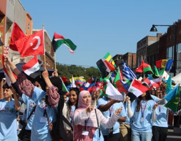 People hold a number of different countries' flags during the Upper Darby International Festival