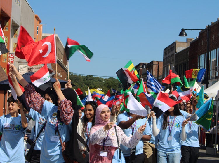 People hold a number of different countries' flags during the Upper Darby International Festival