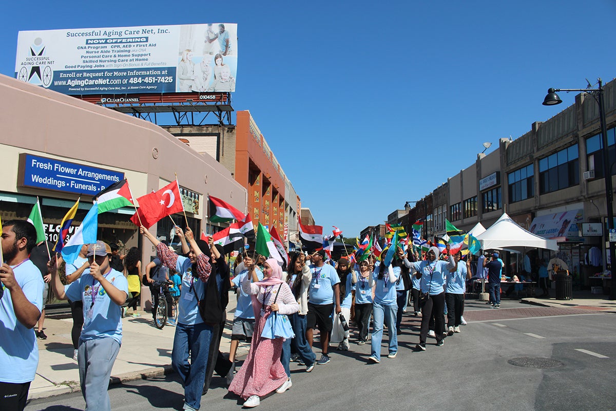 Children and community members paraded with flags from different countries in front of the municipal building at Upper Darby's International Festival