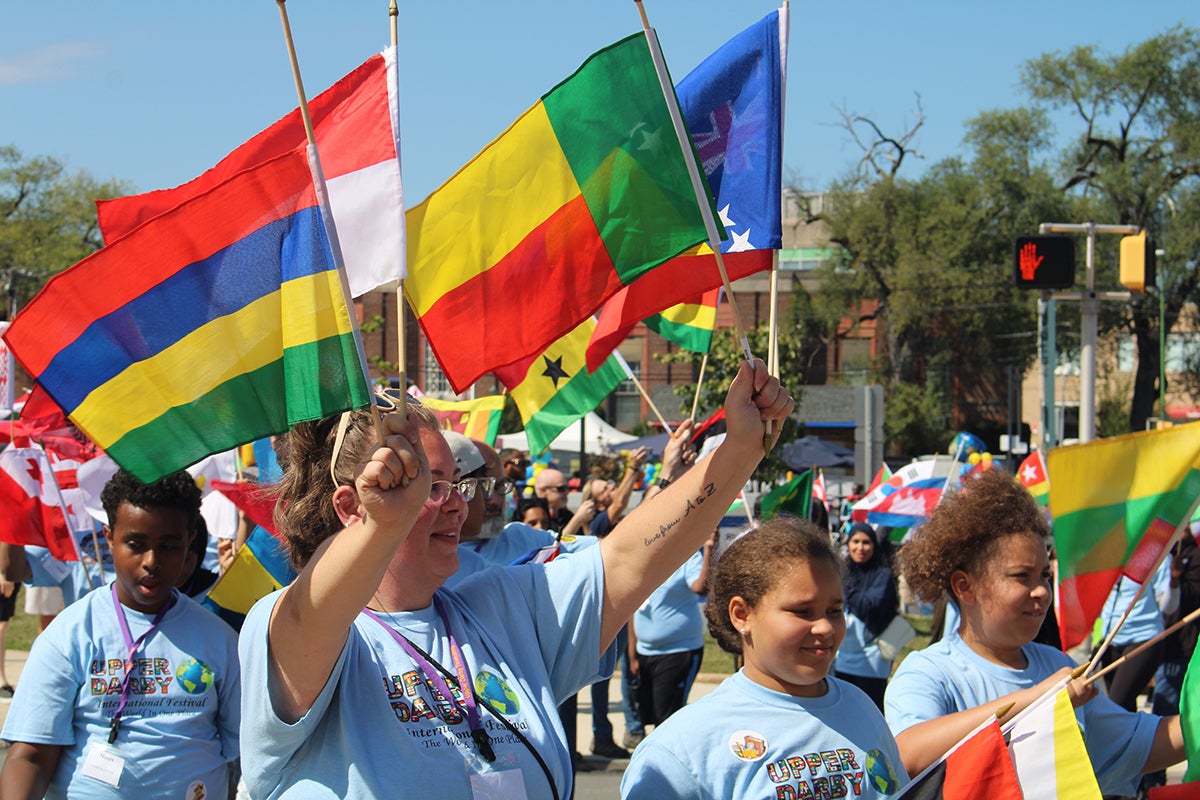 Children and community members paraded with flags from different countries in front of the municipal building at Upper Darby's International Festival