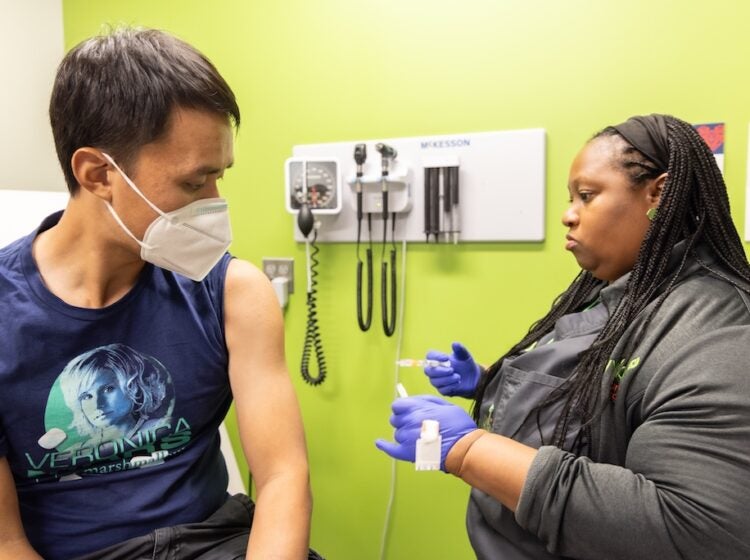 WHYY’s the Pulse reporter Alan Yu receives his influenza vaccine at a Vybe urgent care center in Philadelphia. (Kimberly Paynter/WHYY)