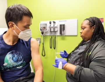 WHYY’s the Pulse reporter Alan Yu receives his influenza vaccine at a Vybe urgent care center in Philadelphia. (Kimberly Paynter/WHYY)