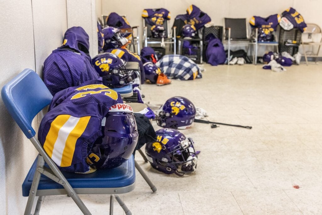 Bags and other football gear stacked on top of chairs