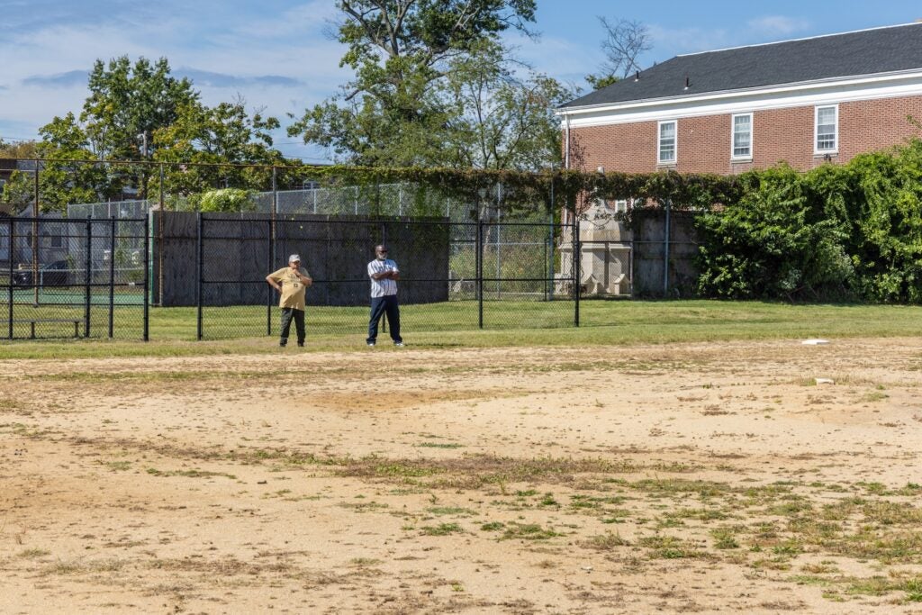 Two men standing in the distance on a baseball field