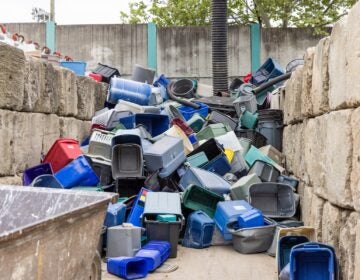 A large stack of bins piled up against the wall