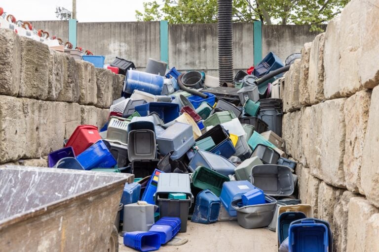A large stack of bins piled up against the wall