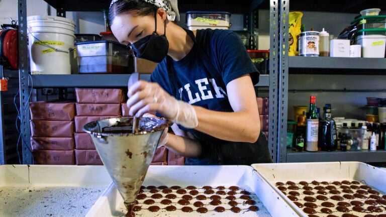 10 28 2025 k paynter chocolate making-3 A worker drops liquid chocolate onto sprinkles