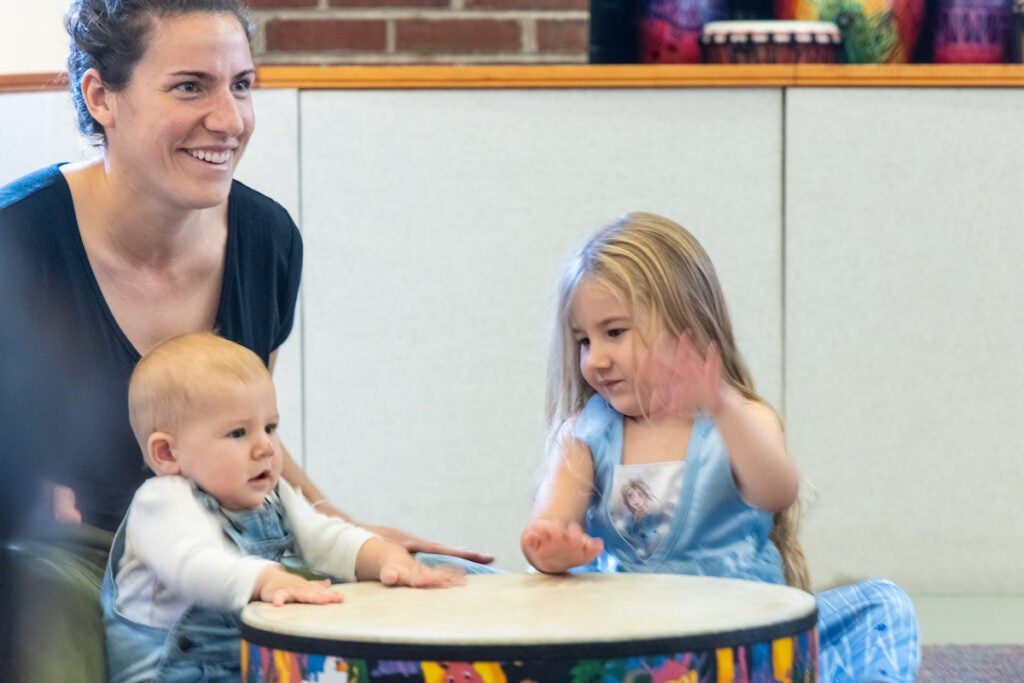 Nicolette Hankh and her children playing a drum during music class