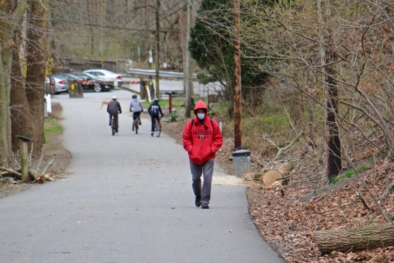 People walk along the multi-use trail at Ridley Creek State Park in Media, Pa.
