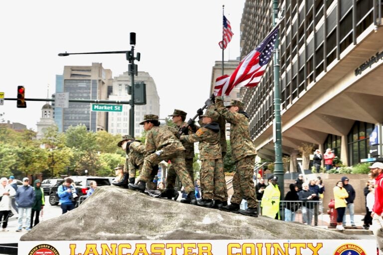 Members of the Lancaster County Young Marines recreate a moment from the Battle of Iwo Jima on a float