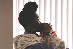 247x164_AmericanDelivery Woman kissing baby on head and gazing out window