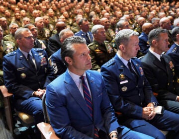 Defense Secretary Pete Hegseth, center, sitting with Chairman of the Joint Chiefs of Staff Air Force Gen. Dan Caine, third from right, and U.S. military senior leadership as they listen to President Donald Trump speaks at Marine Corps Base Quantico, Tuesday, Sept. 30, 2025 in Quantico, Va. (AP Photo/Evan Vucci)
