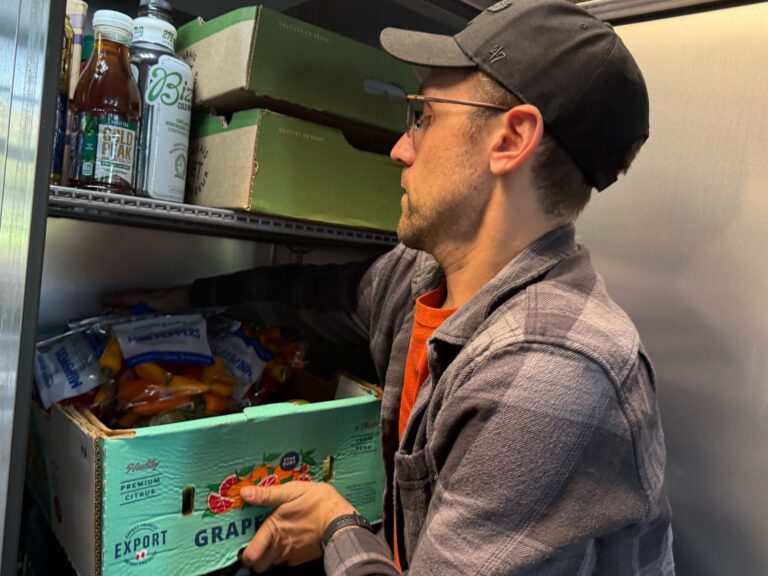 A man loads foot for SNAP recipients onto a shelf