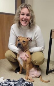 A woman posing for a photo with a dog