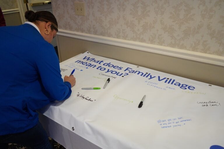 event-attendees-sign-banner-kc-102425 Event attendees sign a banner
