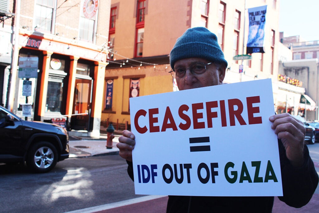 Maynard Seider holds up a sign that reads "Ceasefire = IDF out of Gaza"