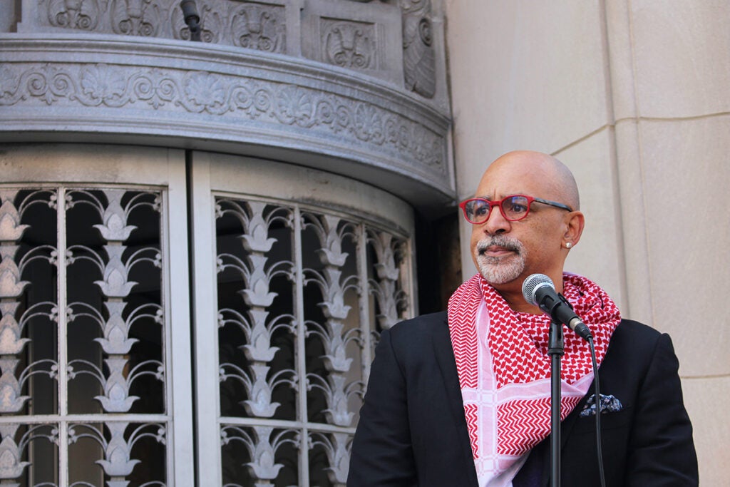 State Rep. Chris Rabb speaks into a microphone outside of Sen. John Fetterman's Old City office