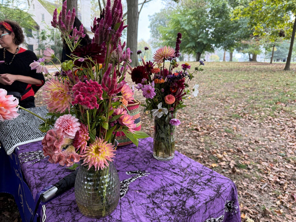 Bouquets of flowers sit on a table outside