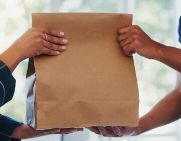 A paper bag being handed over in a store