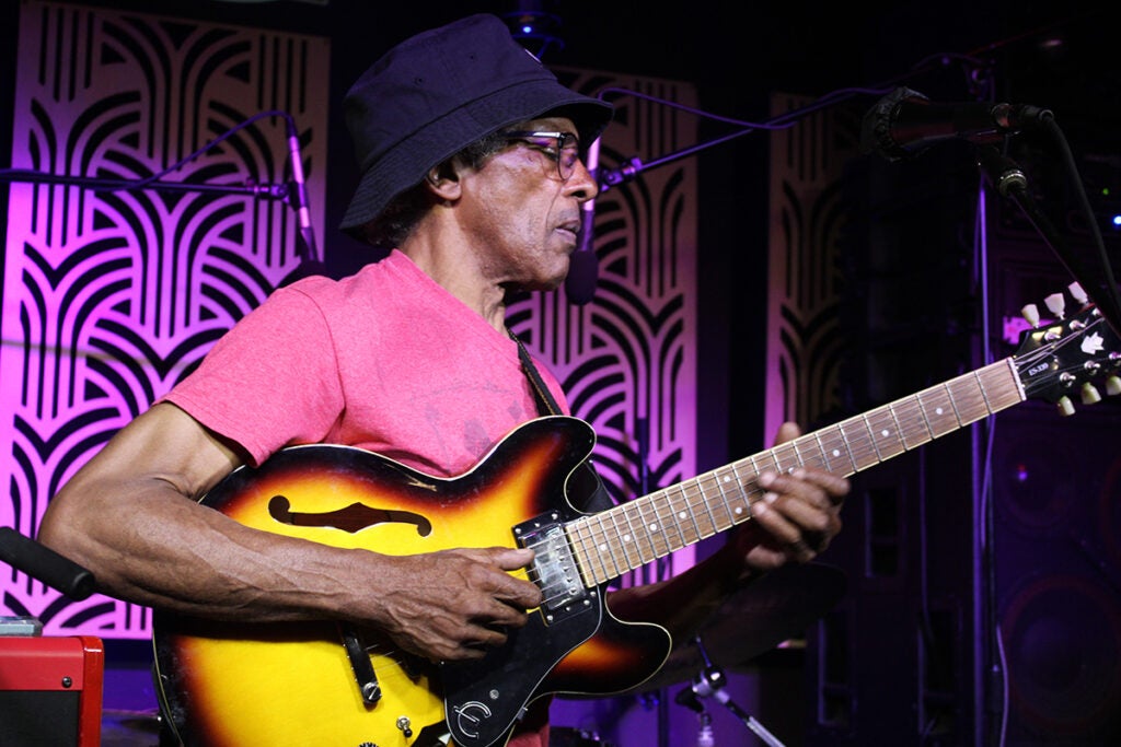 Clarence Spady, internationally renowned blues guitarist and singer, performs on stage with a guitar