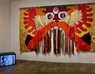 Moki Cherry's colorful tapestry is juxtaposed with a video