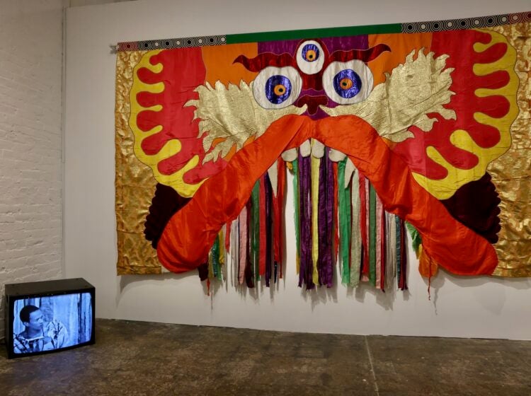 Moki Cherry's colorful tapestry is juxtaposed with a video